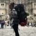 Женщина с рюкзаком идёт по улицам иностранного города в одиночестве