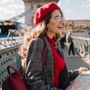 Туристы с рюкзаками и картой на фоне европейских достопримечательностей