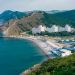 Пейзаж с морем, горами и городом — символ путешествий 2025 года